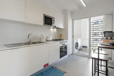 a white kitchen with a sink and a microwave at Conde Casa Branca by LovelyStay in Funchal