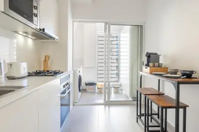 a kitchen with white cabinets and a wooden table at Conde Casa Branca by LovelyStay in Funchal