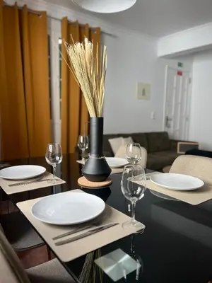 a dining room table with plates and wine glasses at Brisa do Norte apartment in São Vicente