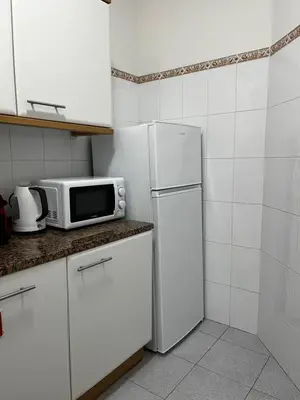 a kitchen with a white refrigerator and a microwave at Brisa do Norte apartment in São Vicente