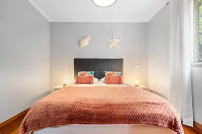 a bedroom with a large bed with orange comforter at Peace Haven II in Calheta