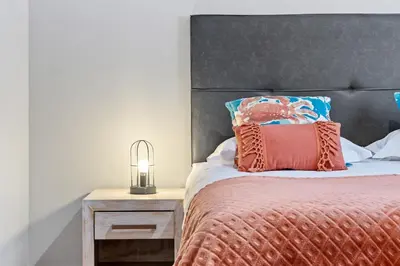 a bedroom with a bed with a black headboard and a lamp at Peace Haven II in Calheta