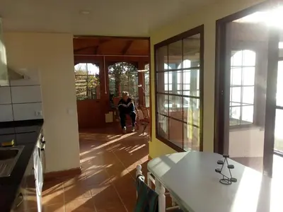 a woman sitting in a chair in a kitchen at Holiday Home Erdhaus by Interhome in Fajã da Ovelha