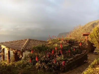 a house with a garden with red flowers at Holiday Home Erdhaus by Interhome in Fajã da Ovelha