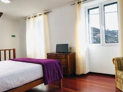 a bedroom with a bed and a tv on a table at Holiday Home Casa Lugar da Ribeira mit Dachterrasse by Interhome in Campanário