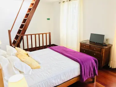 a bedroom with a bed and a staircase and a desk at Holiday Home Casa Lugar da Ribeira mit Dachterrasse by Interhome in Campanário