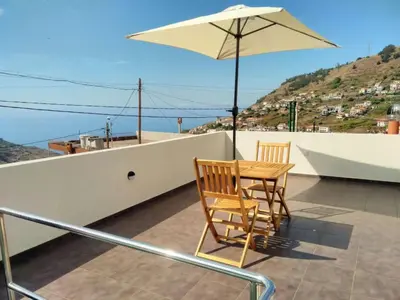 a table and chairs on a balcony with an umbrella at Holiday Home Casa Lugar da Ribeira mit Dachterrasse by Interhome in Campanário