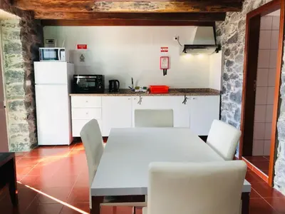 a kitchen with a white table and white chairs at Holiday Home Casa Lugar da Ribeira mit Dachterrasse by Interhome in Campanário