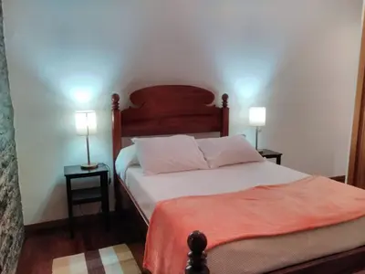 a bedroom with a bed with two lamps on two tables at Holiday Home Quinta do Serrado by Interhome in Ribeira da Janela