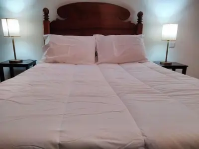 a large white bed with pillows and two lamps at Holiday Home Quinta do Serrado by Interhome in Ribeira da Janela