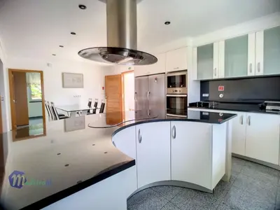 a kitchen with white cabinets and a black counter top at Holiday Home Yohannas Unterkunft by Interhome in Campanário