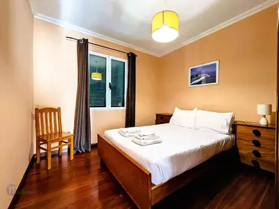 a bedroom with a bed and a chair and a window at Apartment Domus Dino by Interhome in Porto da Cruz