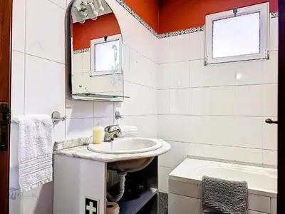 a bathroom with a sink and a mirror and a tub at Apartment Domus Dino by Interhome in Porto da Cruz