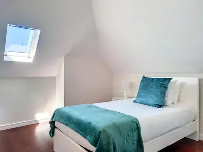 a bedroom with a bed with a blue pillow on it at Holiday Home Urlaubshaus Vier Generationen by Interhome in Seixal