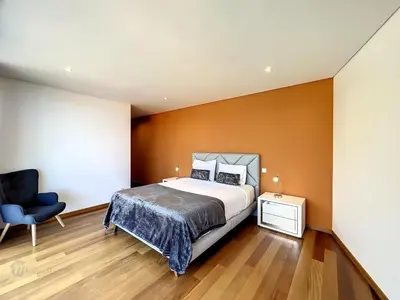 a bedroom with a large bed and a blue chair at Holiday Home Traumhaus 2- von LSAMadeira by Interhome in Calheta