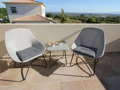 two chairs and a side table on a balcony at Holiday Home Vila Marques da Luz by Interhome in Montinhos da Luz