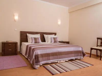 a bedroom with a large bed with a wooden headboard at Holiday Home Elegantes Haus in Santana mit Garten und Grill by Interhome in Santana