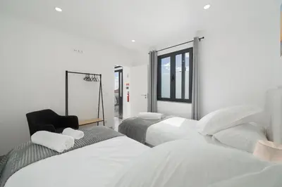 a bedroom with three beds and a window at OurMadeira - Casa da Vinha in Câmara de Lobos
