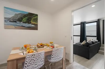 a dining room with a table and a couch at OurMadeira - Casa da Vinha in Câmara de Lobos