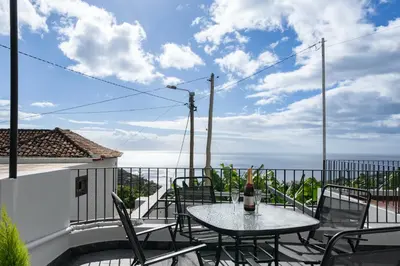 a patio with a table and chairs on a balcony at OurMadeira - Casa da Vinha in Câmara de Lobos
