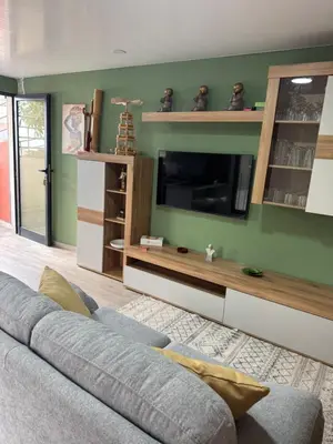 a living room with a couch and a flat screen tv at O Refúgio in Calheta