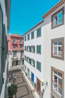 a kitchen with white cabinets and a stove top oven at Tanoeira apartment in Funchal