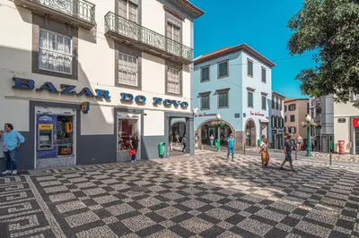 a group of people walking down a street in a town at Tanoeira apartment in Funchal