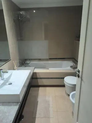 a bathroom with a tub and a toilet and a sink at Casa Amarillo in Lagos