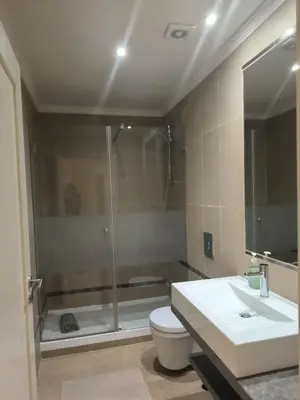 a bathroom with a shower and a toilet and a sink at Casa Amarillo in Lagos