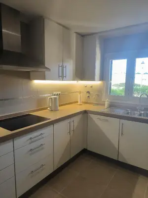 a kitchen with white cabinets and a sink and a window at Casa Amarillo in Lagos