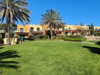 a large yard with palm trees in front of a building at Casa Amarillo in Lagos