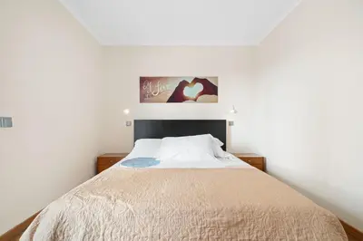 a bed in a room with a white wall at Lido Retreat Apartment in Funchal