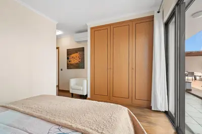 a bedroom with a bed and a sliding door at Lido Retreat Apartment in Funchal