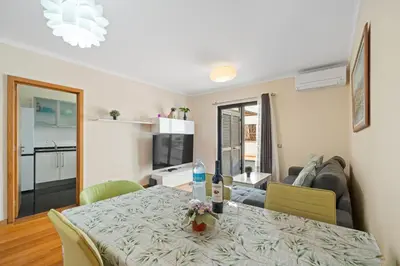 a living room with a dining room table and a kitchen at Lido Retreat Apartment in Funchal