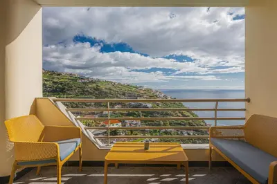 a balcony with chairs and a view of the ocean at New Calheta Plaza Apartment by Your Madeira Rentals in Estreito da Calheta