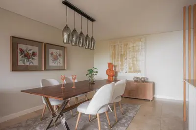 a dining room with a wooden table and white chairs at New Calheta Plaza Apartment by Your Madeira Rentals in Estreito da Calheta