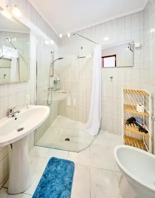 a white bathroom with a sink and a shower at S&I Chillhouse Funchal in Funchal