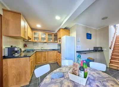 a kitchen with a table with chairs and a refrigerator at S&I Chillhouse Funchal in Funchal