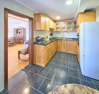 a kitchen with wooden cabinets and a white refrigerator at S&I Chillhouse Funchal in Funchal