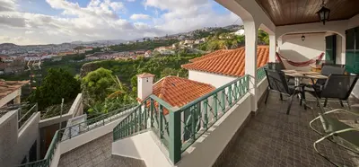 a balcony of a house with a table and chairs at S&I Chillhouse Funchal in Funchal