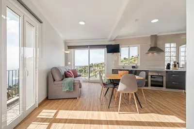 a kitchen and dining room with a table and chairs at Casa da Feira in Calheta