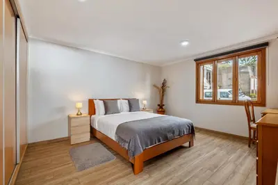 a room with wooden ceilings and a large window at Casa da Feira in Calheta