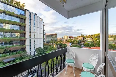 a balcony with chairs and a view of a city at MG Hollidays - Av Infante Funchal in Funchal