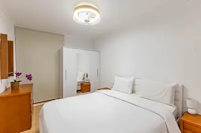 a white bedroom with a large white bed with white pillows at MG Hollidays - Av Infante Funchal in Funchal