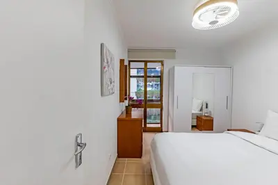 a white bedroom with a bed and a mirror at MG Hollidays - Av Infante Funchal in Funchal