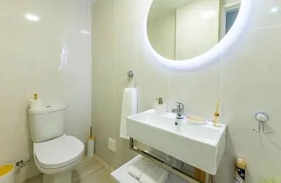 a white bathroom with a toilet and a sink at MG Hollidays - Av Infante Funchal in Funchal