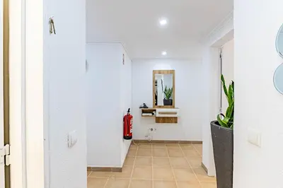 a hallway with a red fire hydrant in a white room at MG Hollidays - Av Infante Funchal in Funchal