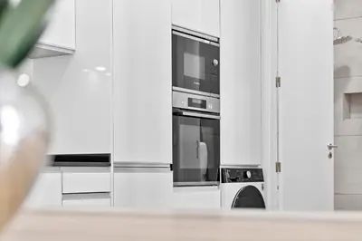 a kitchen with white cabinets and a microwave at Solar dos Reis in Funchal