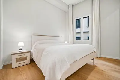 a white bedroom with a large bed and a window at Solar dos Reis in Funchal