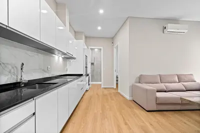 a kitchen with white cabinets and a couch at Solar dos Reis in Funchal